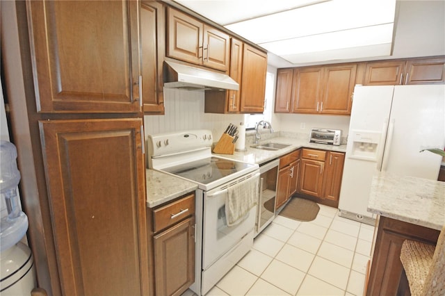 kitchen with light stone counters, sink, white appliances, and light tile patterned floors