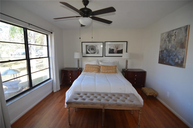 bedroom with ceiling fan, wood-type flooring, and multiple windows