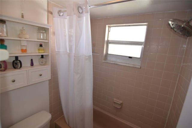 bathroom with shower / bath combination with curtain and toilet