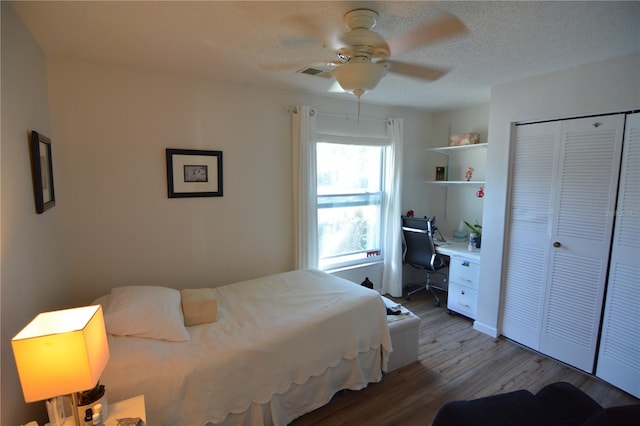 bedroom featuring hardwood / wood-style flooring, ceiling fan, a closet, and a textured ceiling