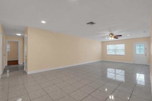 empty room with light tile patterned floors and ceiling fan