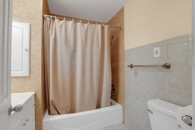 full bathroom with tile walls, vanity, toilet, and shower / tub combo with curtain