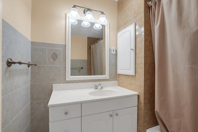 bathroom with vanity and tile walls