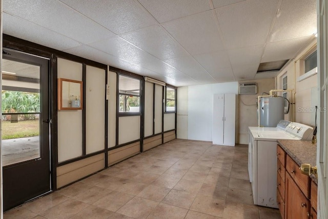 laundry area featuring cabinets, electric water heater, and a wall unit AC