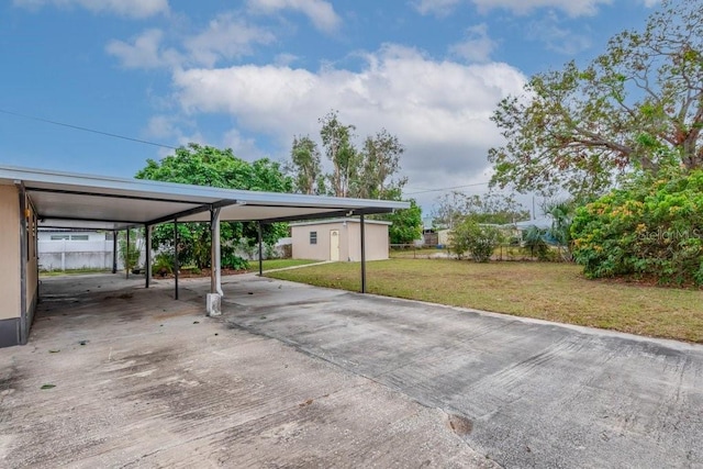 view of parking with concrete driveway and fence