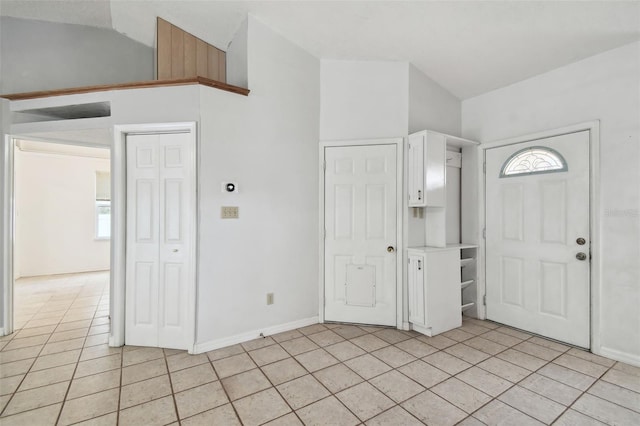 foyer featuring vaulted ceiling and light tile patterned floors