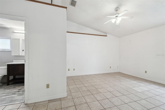 tiled empty room featuring ceiling fan, a textured ceiling, and lofted ceiling