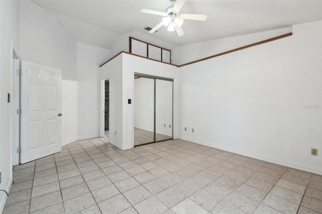 unfurnished bedroom with a closet, ceiling fan, and high vaulted ceiling