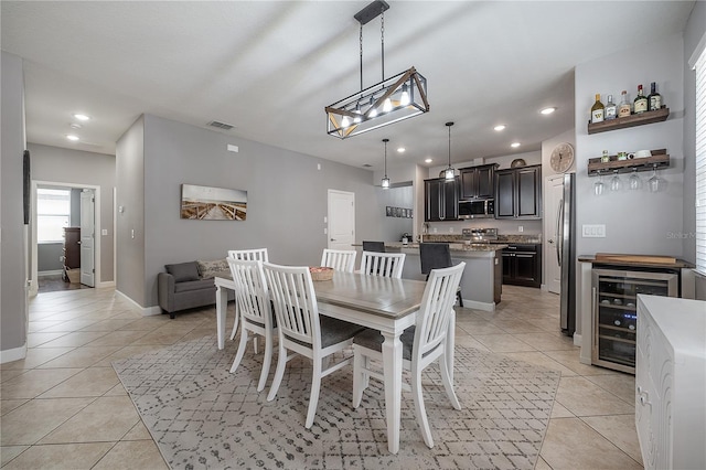 dining area with wine cooler, light tile patterned floors, and bar