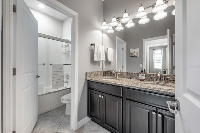 full bathroom featuring toilet, tile patterned floors, bath / shower combo with glass door, and vanity