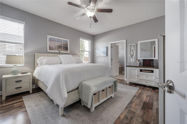 bedroom with dark wood-type flooring, ceiling fan, and ensuite bath