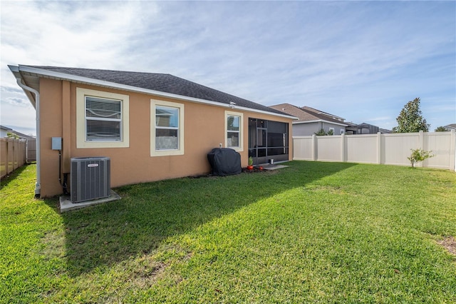 back of property featuring a lawn and central air condition unit