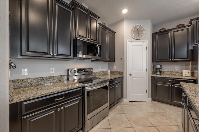 kitchen with light stone countertops, appliances with stainless steel finishes, light tile patterned floors, and a textured ceiling