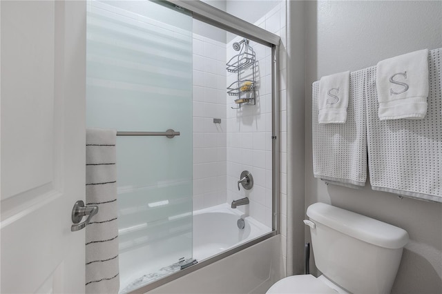 bathroom with bath / shower combo with glass door and toilet