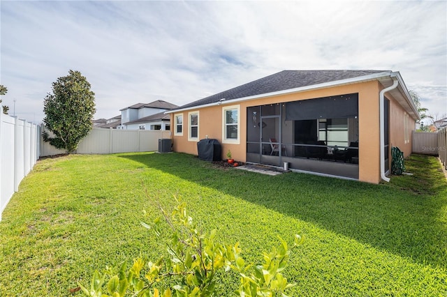 back of house featuring a lawn and central air condition unit