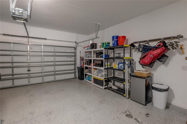 garage featuring stainless steel refrigerator and a garage door opener