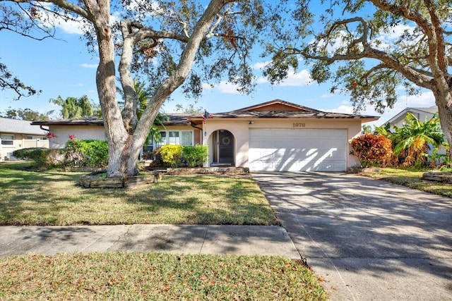 single story home with a garage and a front lawn