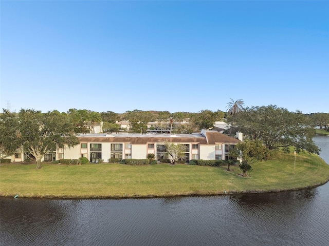 view of front facade with a water view and a front lawn