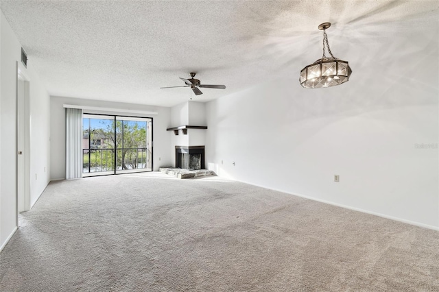 unfurnished living room featuring ceiling fan, carpet, and a textured ceiling