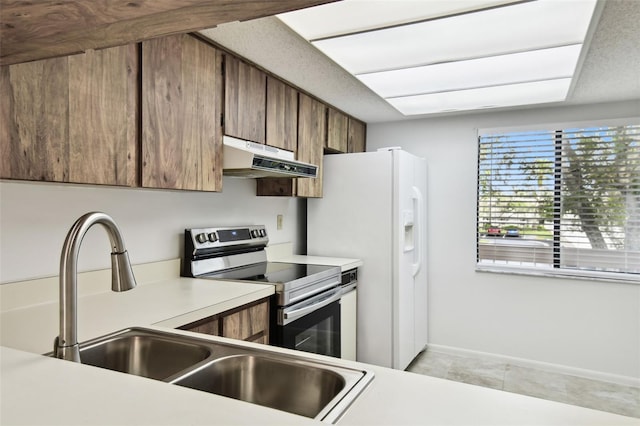 kitchen featuring stainless steel range with electric stovetop, white refrigerator with ice dispenser, and sink