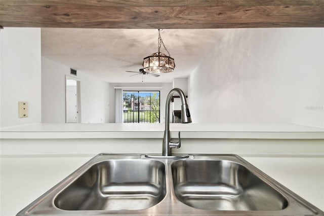 room details with pendant lighting, sink, and a textured ceiling