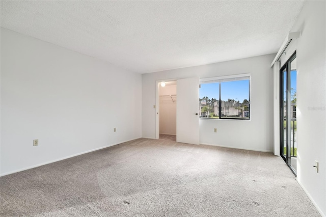 spare room with light carpet and a textured ceiling