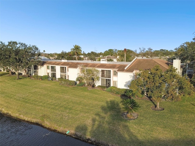 single story home with a front lawn and a water view