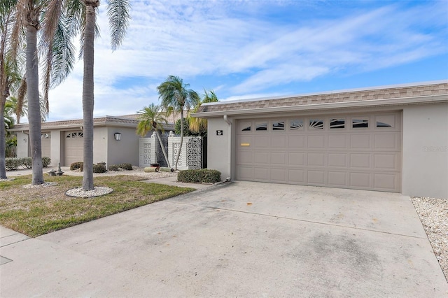 ranch-style house with a garage, a shingled roof, concrete driveway, and stucco siding