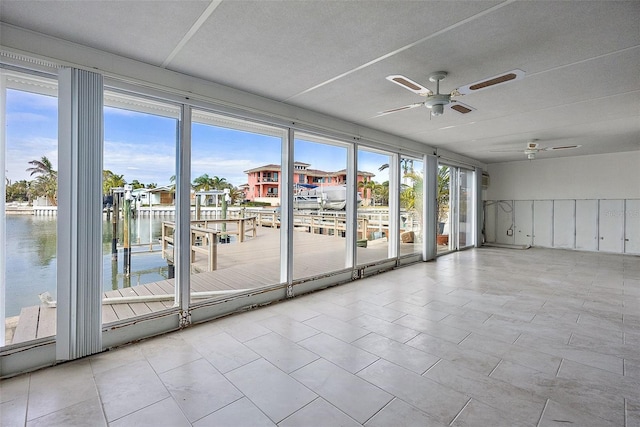 empty room featuring ceiling fan and a water view