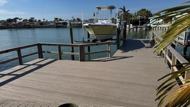 dock area with a water view and boat lift