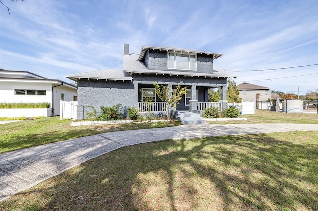 view of front of property with covered porch and a front yard