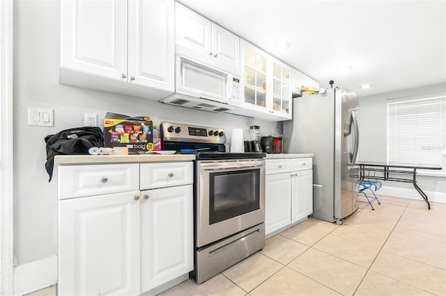 kitchen featuring light tile patterned floors, stainless steel appliances, and white cabinetry