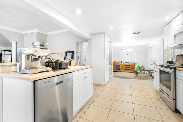 kitchen with white cabinetry, appliances with stainless steel finishes, ornamental molding, light tile patterned floors, and ornate columns