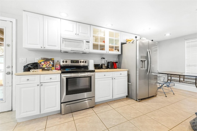 kitchen with light tile patterned floors, white cabinets, and appliances with stainless steel finishes