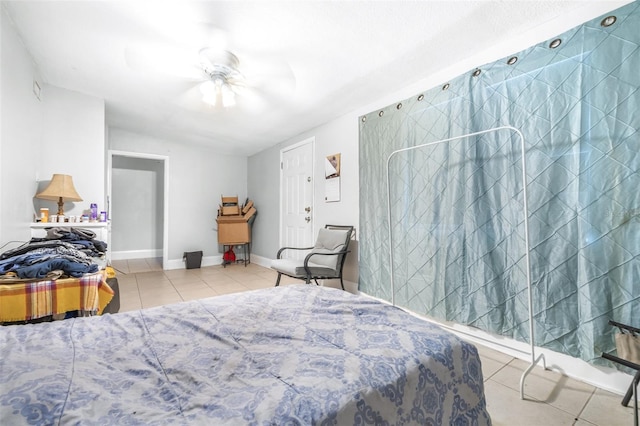 bedroom featuring ceiling fan, lofted ceiling, and light tile patterned flooring