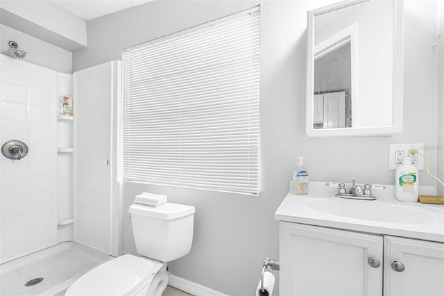 bathroom featuring toilet, vanity, and a shower