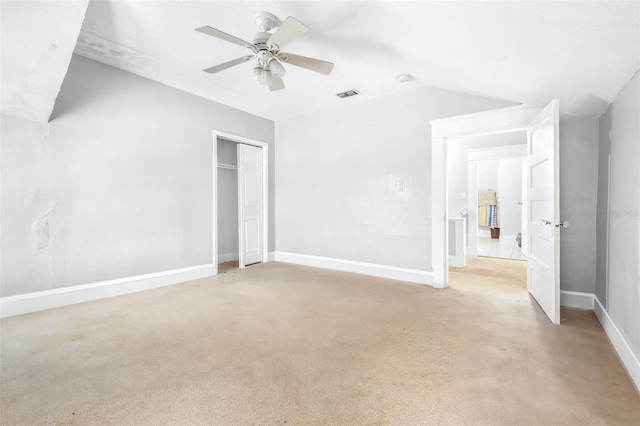 unfurnished bedroom with ceiling fan, a closet, light carpet, and vaulted ceiling