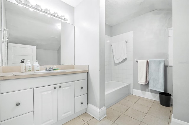 bathroom featuring vanity, tile patterned flooring, and tiled shower / bath