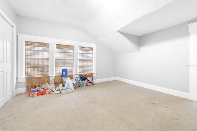 recreation room with carpet and vaulted ceiling