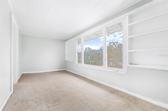 empty room with carpet and built in shelves