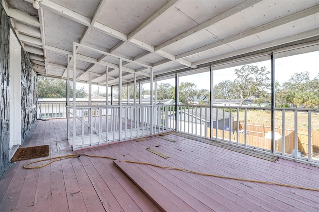 unfurnished sunroom featuring a water view