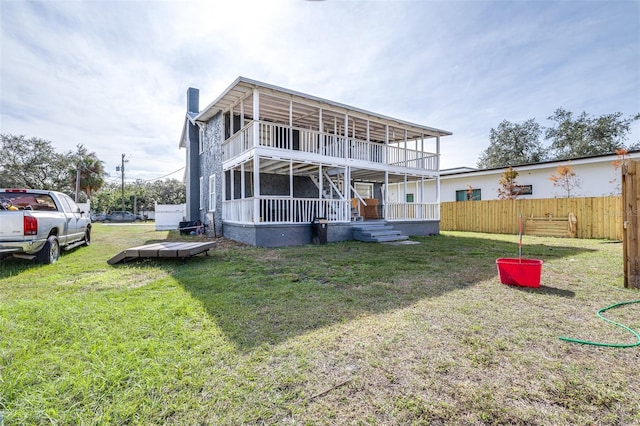 back of house with a balcony, a lawn, and a porch