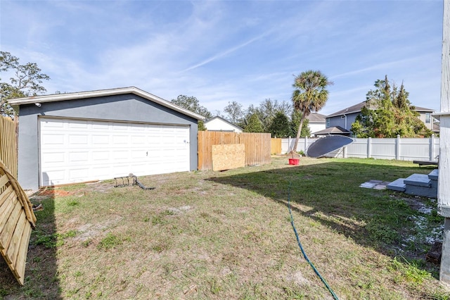 view of yard with a garage and an outbuilding