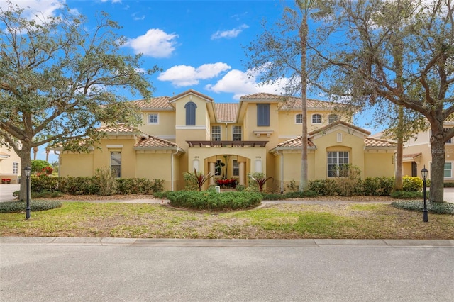 mediterranean / spanish home with a front lawn