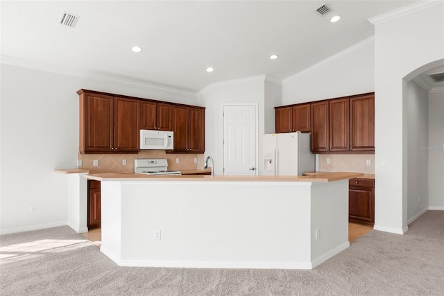 kitchen with tasteful backsplash, white appliances, ornamental molding, an island with sink, and light colored carpet