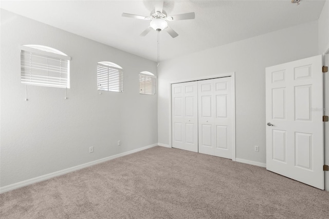 unfurnished bedroom featuring light colored carpet, ceiling fan, and a closet