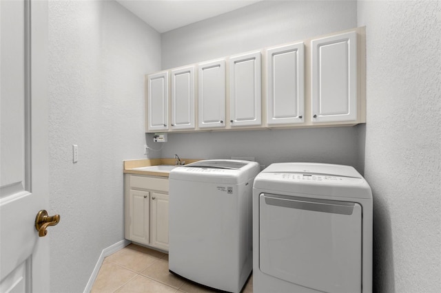 washroom with independent washer and dryer, cabinets, light tile patterned flooring, and sink