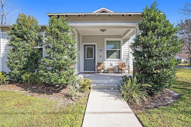 view of front of home featuring covered porch and a front lawn