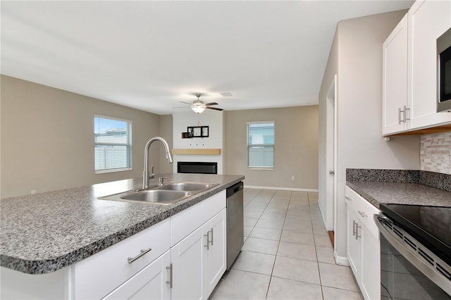 kitchen featuring white cabinetry, appliances with stainless steel finishes, sink, and a center island with sink