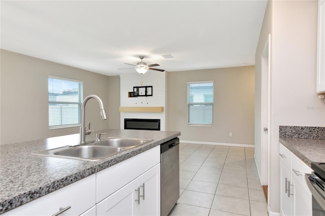 kitchen featuring appliances with stainless steel finishes, sink, white cabinets, light tile patterned floors, and ceiling fan